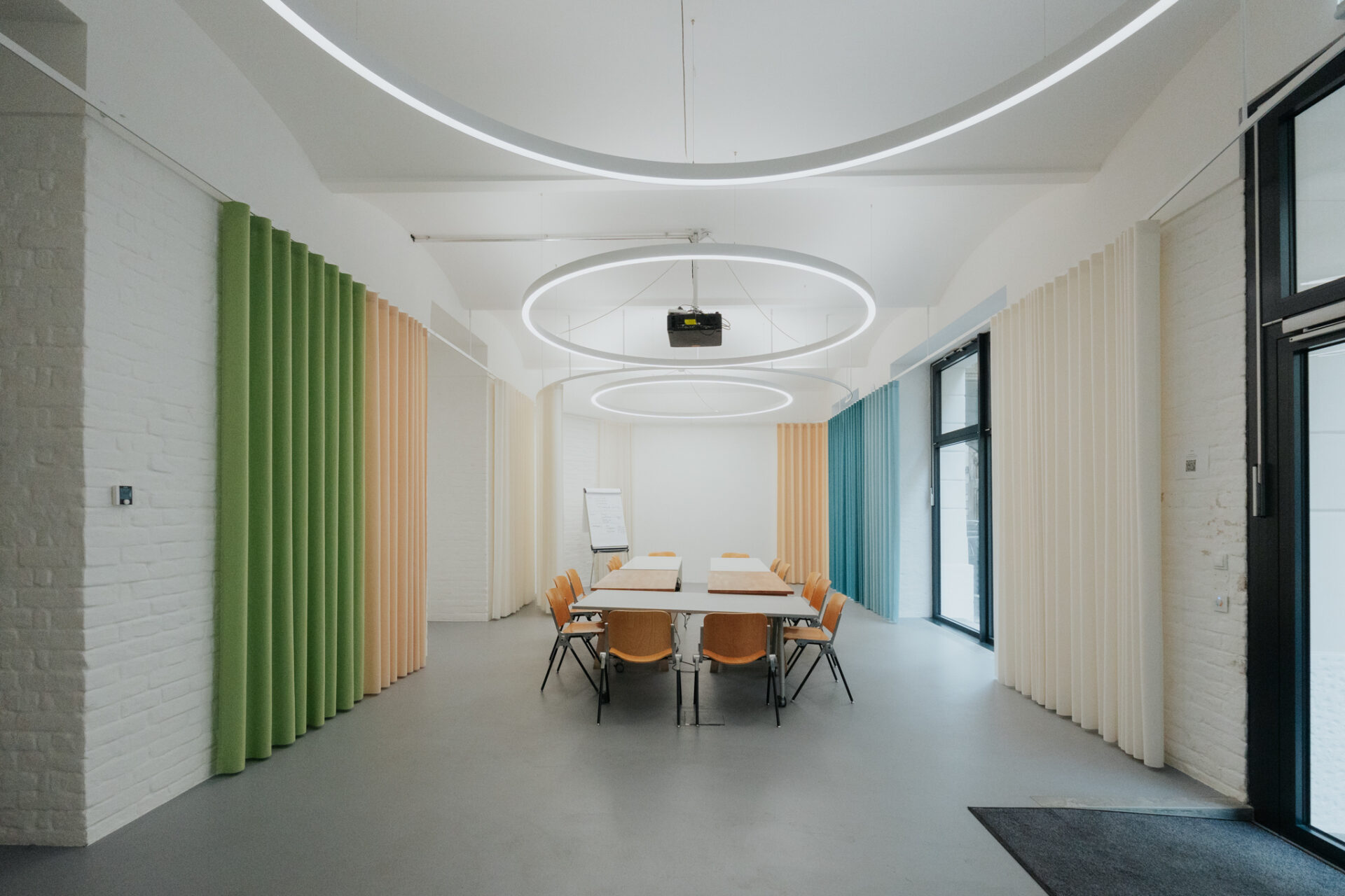 Konferenzraum im Institute of Building Research & Innovation; Tisch, Stühle, Projektor, helle Farben.