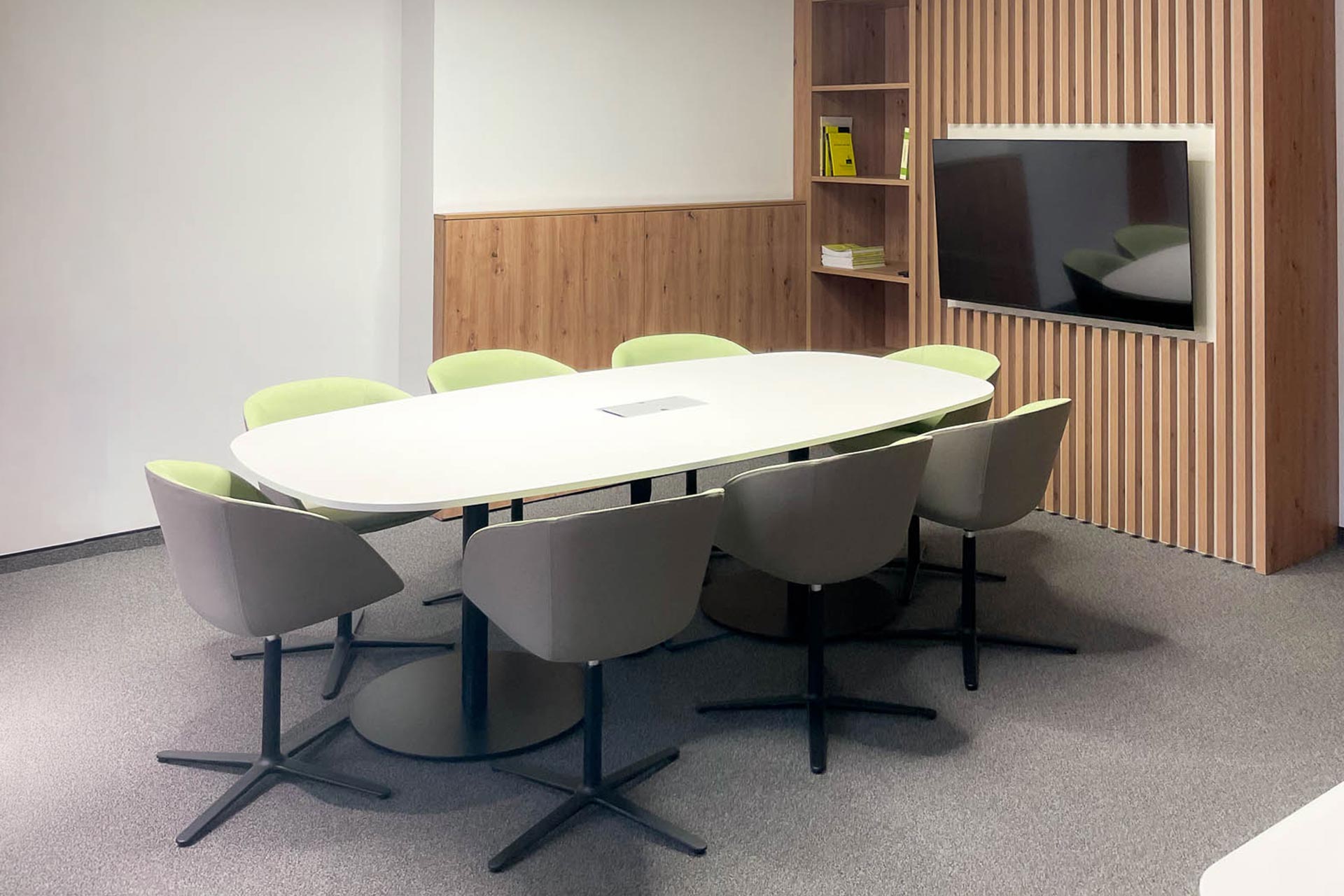 Raiffeisenbank Gloggnitz: Besprechungsraum mit ovalem Tisch, Stühlen und Bildschirm. Bankstelle Gloggnitz Konferenzraum.